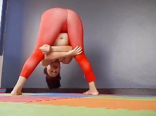 Regina Noir. A woman in yoga leotards practices yoga in the gym. Transparent red leotard yoga.