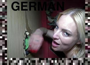 Tattooed blonde German mom gives handjob through gloryhole with cum on face and tits