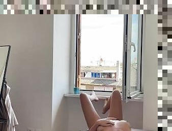Busty blonde masturbates in front of the window