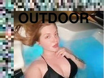 Cute sexy blonde swimming in jacuzzi outdoor