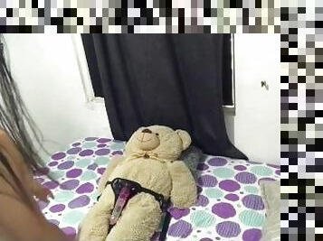 Lesbiana monta al oso de peluche con arns.