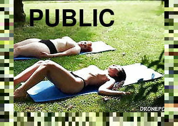 Two naked girls sunbathing in the city park