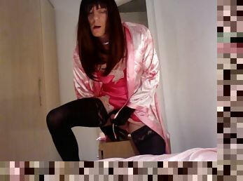 Jess Silk rides a dildo in a pink satin robe and hot pink nightgown with a red wig