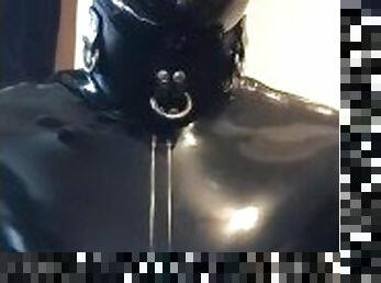 Rubber gimp in chastity shows off