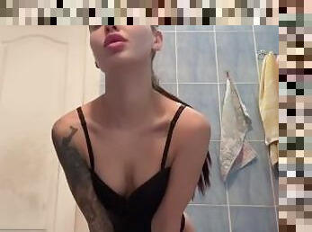 A cute brunette in a swimming costume kneads her breasts in the bathtub.