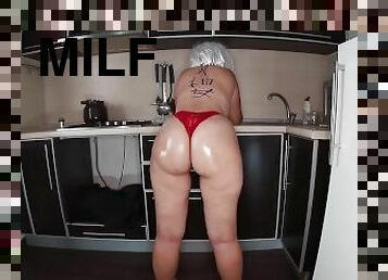 Milf stands in the kitchen in a thong and dreams of anal sex