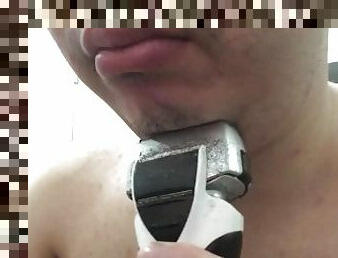 Shaving my beard with a shaver.