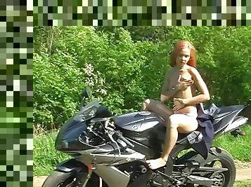 Naked babe masturbates on top of her motorbike