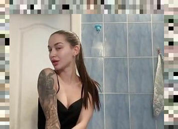 A cute brunette is filmed in the bathtub.