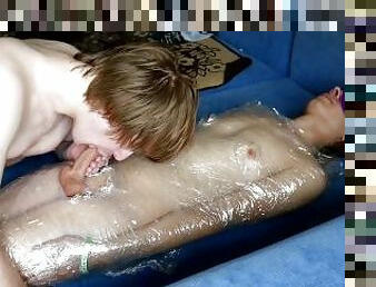 Submissive boy gets wrapped in foil, got his feet and cock used and milked