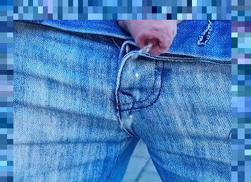 Pissing outdoors wearing jeans