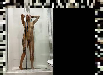 Tattooed girl rides a toy in the shower