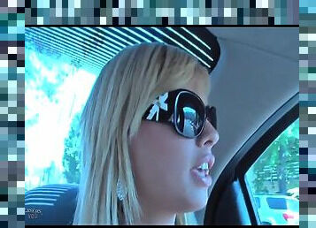 Pretty blonde in sunglasses chats in the car